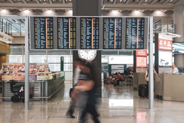 Blurred motion of travelers in a modern airport terminal with departure screens and a prominent clock.