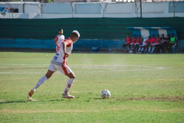 Male soccer player in action on the field during a sunny day match.
