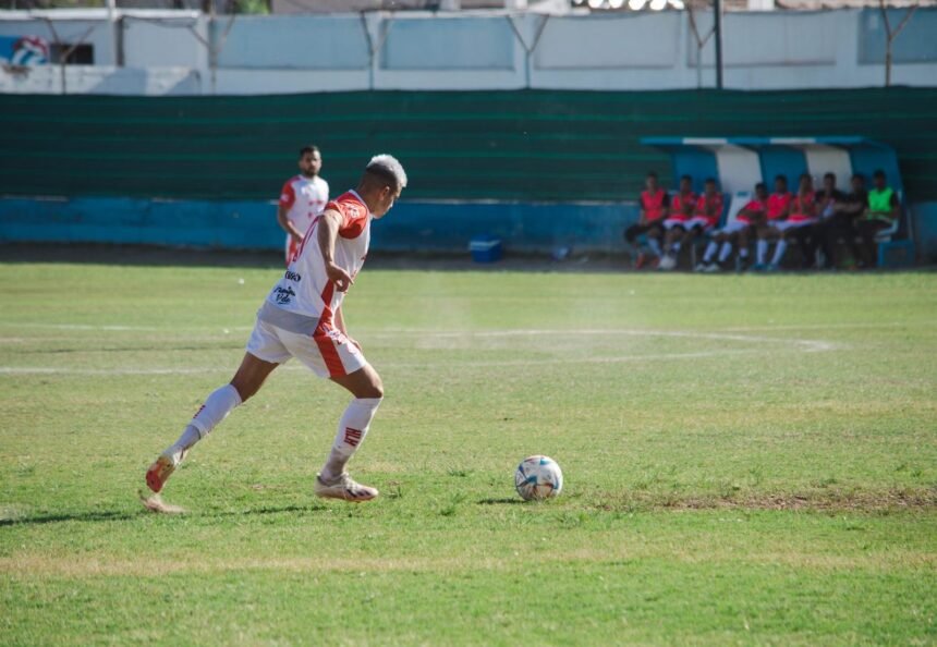 Male soccer player in action on the field during a sunny day match.