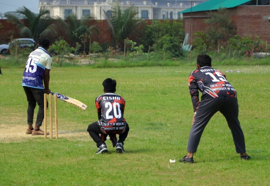 Cricket players in action on a sunny day at an outdoor field.