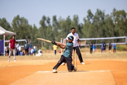 Cricket player skillfully hitting a ball during a lively outdoor match on a sunny day.