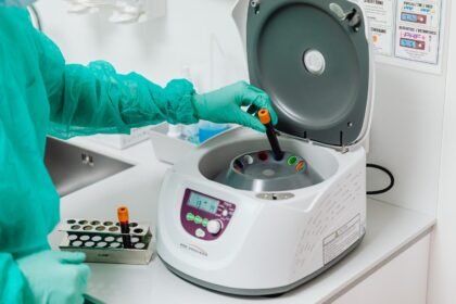 A healthcare professional operates a centrifuge machine in a laboratory, ensuring sterile medical procedures.
