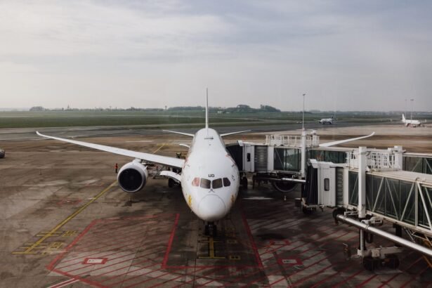 A modern jet airplane docked at an airport terminal gate, ready for boarding on a cloudy day.