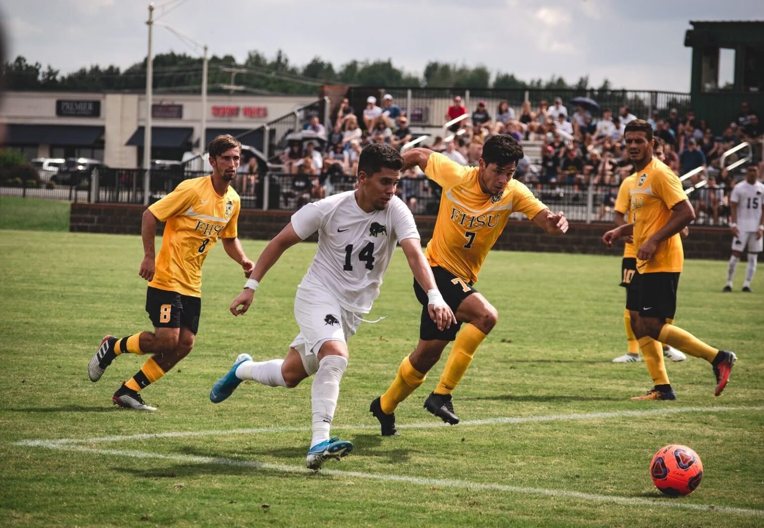 Exciting soccer match with players in motion and enthusiastic spectators.