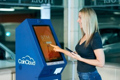 A woman interacts with a CoinCloud machine indoors, showcasing modern digital banking.