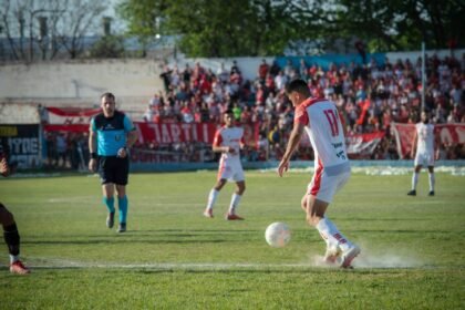 Intense football match showcasing players' skills on a sunny day in Mendoza, Argentina.