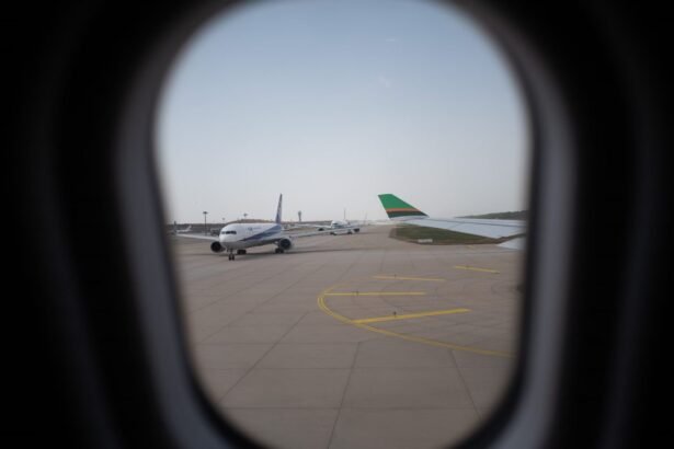 Airplane seen through a window, parked on the airport runway, capturing a travel moment.