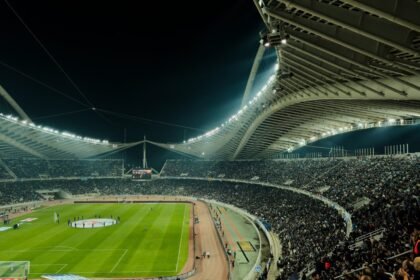 A crowded soccer stadium under bright lights at night, capturing the excitement of a live sports event.