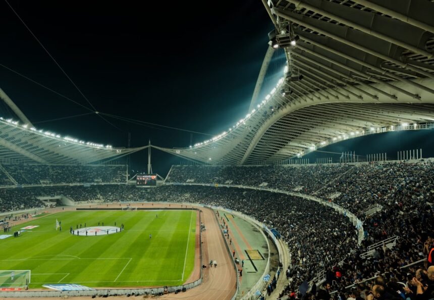 A crowded soccer stadium under bright lights at night, capturing the excitement of a live sports event.