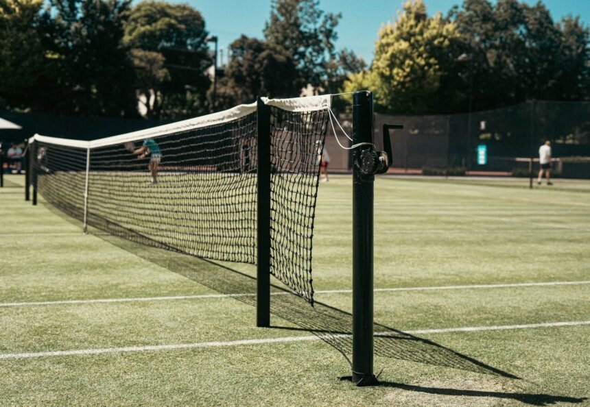 Grass tennis court with net at park in Melbourne, Australia. Perfect for leisure and sports enthusiasts.