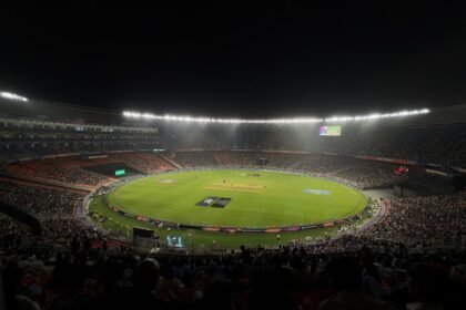 A captivating night cricket match with a large crowd at Narendra Modi Stadium in Ahmedabad, India.