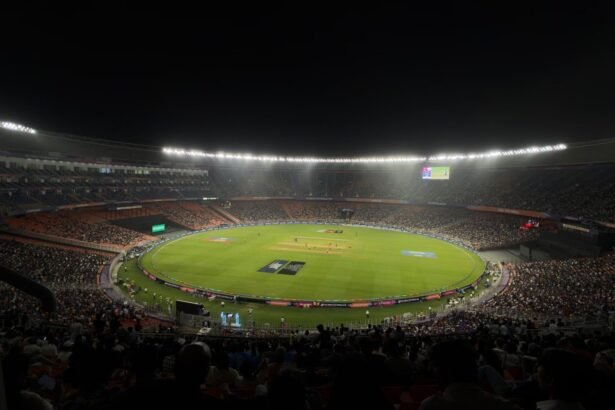 A captivating night cricket match with a large crowd at Narendra Modi Stadium in Ahmedabad, India.