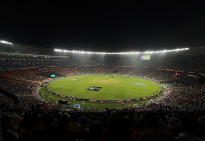 A captivating night cricket match with a large crowd at Narendra Modi Stadium in Ahmedabad, India.