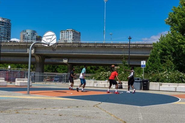 A group of friends enjoying a lively basketball game on an urban outdoor court under a clear blue sky.